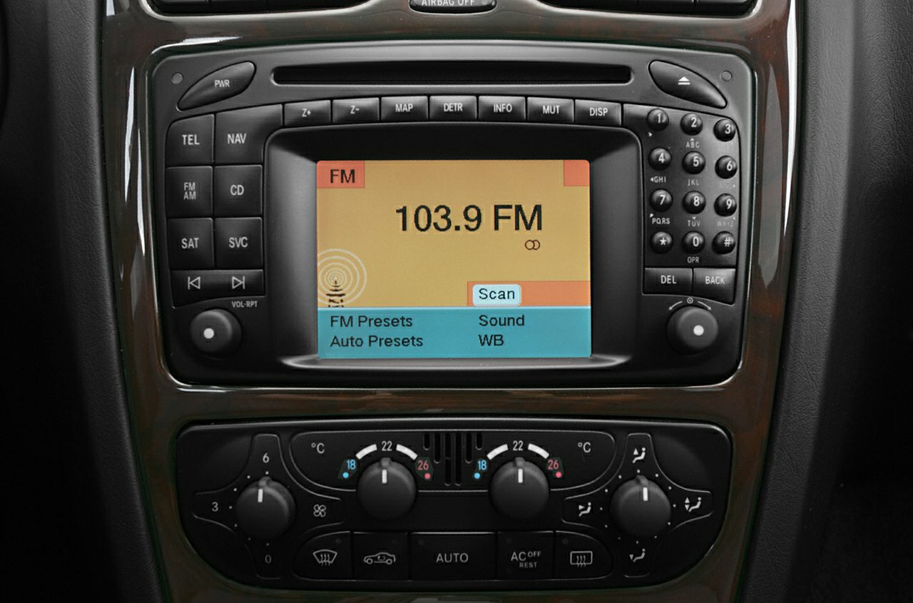 Car radio system displaying 103.9 FM with climate control dials