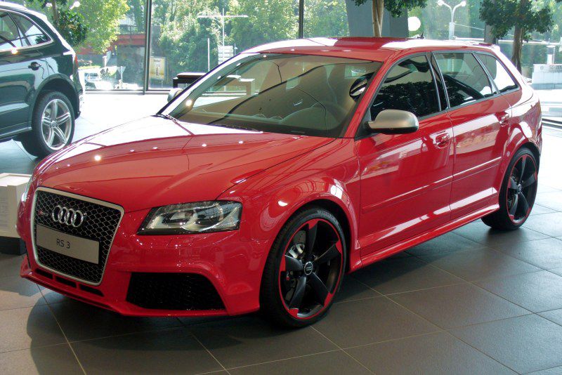 Red sportback with black rims and aggressive front grille design