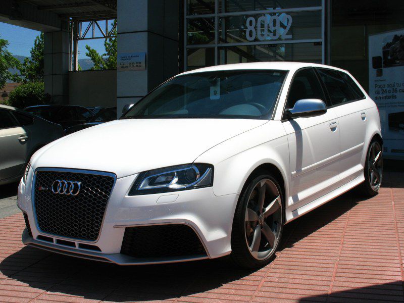 White hatchback with sporty grille and alloy wheels, front side view