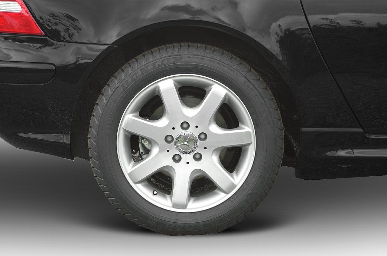 Closeup of a 5-spoke alloy wheel with tire on a black vehicle