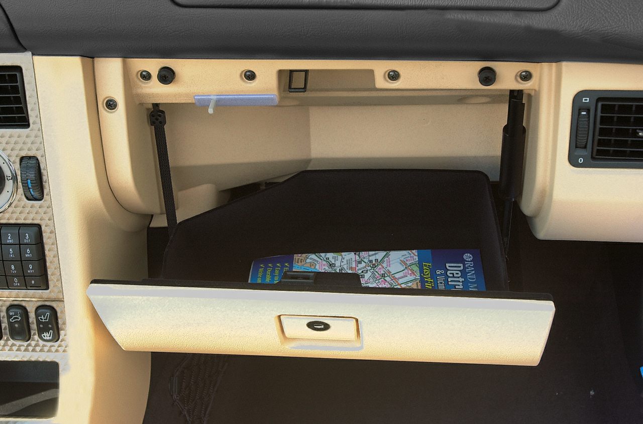 Open glove compartment with visible map and dashboard controls