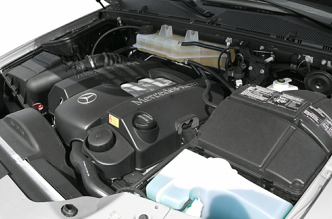 Engine bay with Mercedes-Benz branded engine cover and visible components