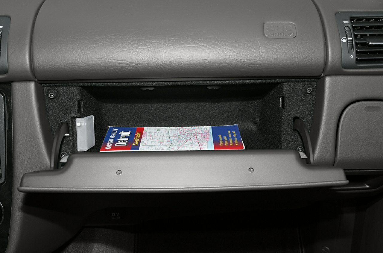 Open glove compartment with map inside in car interior