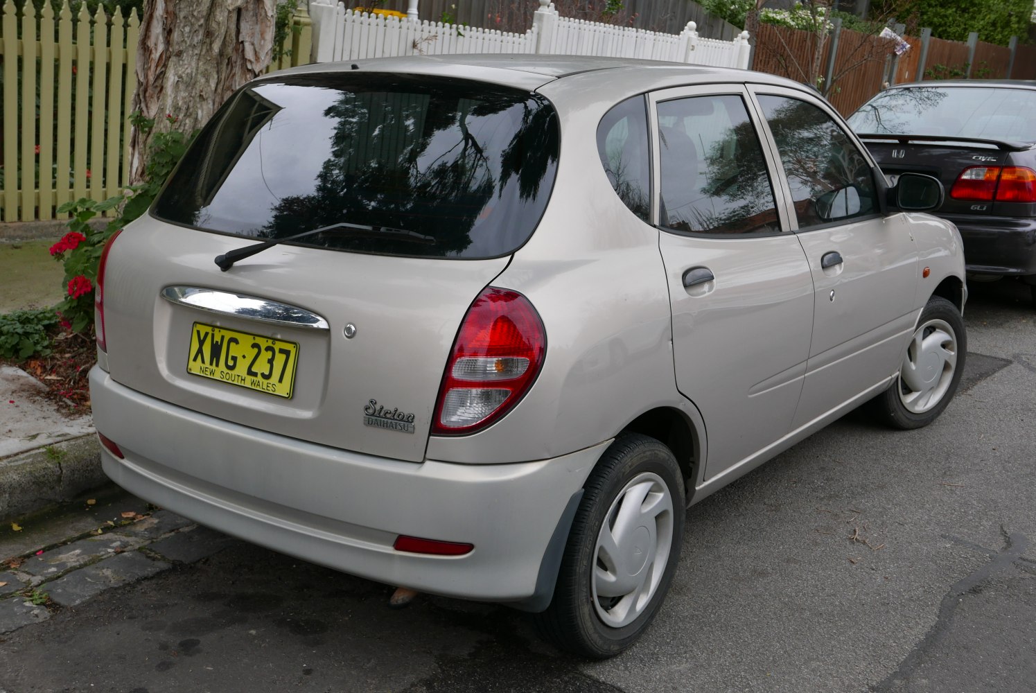 Rear view of a compact hatchback with rounded taillights and rear window wiper.