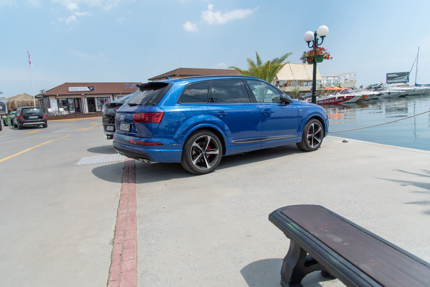 Blue SUV with sport rims and rear roof spoiler near waterfront