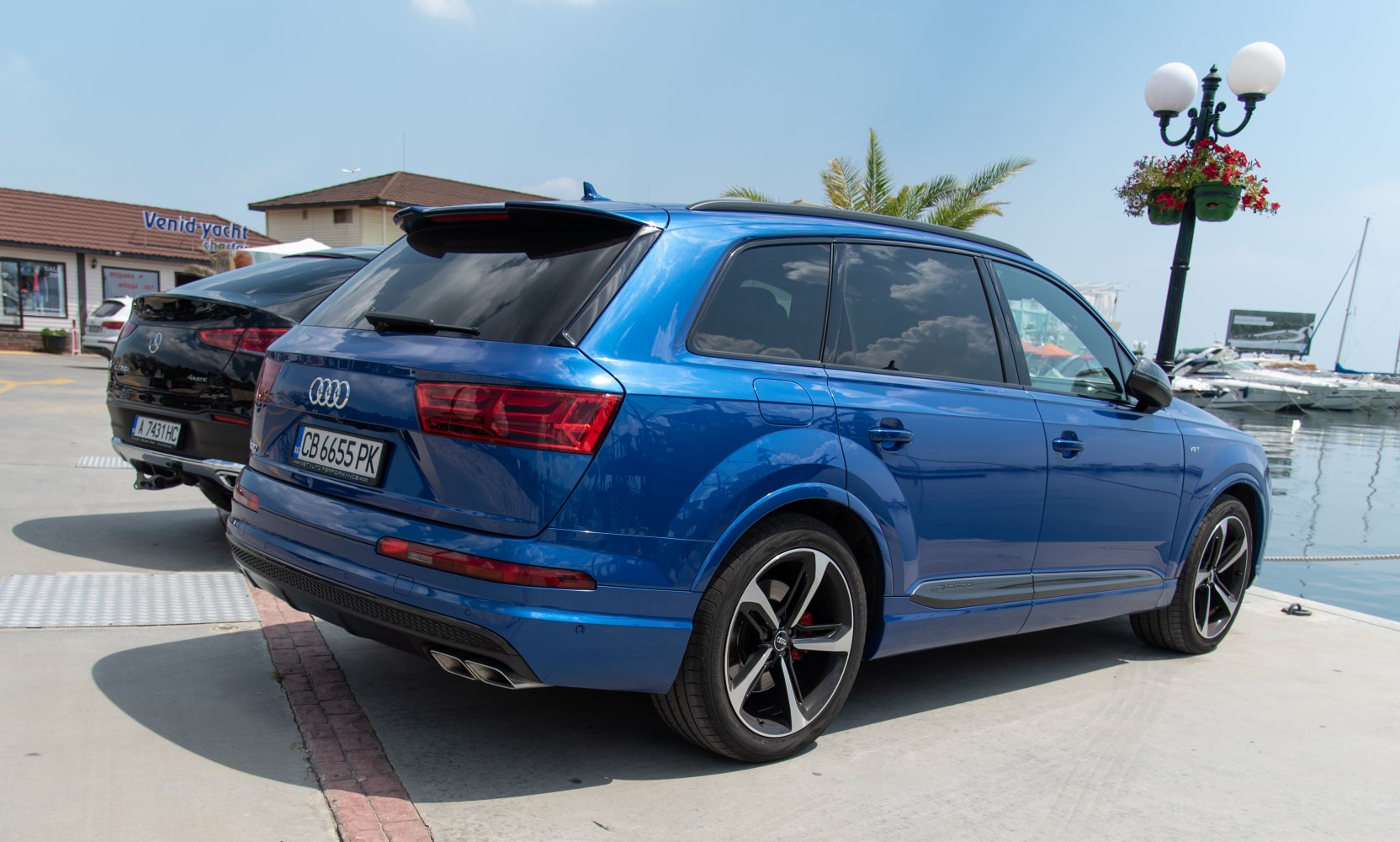 Blue SUV rear-side with tinted windows and dual exhausts