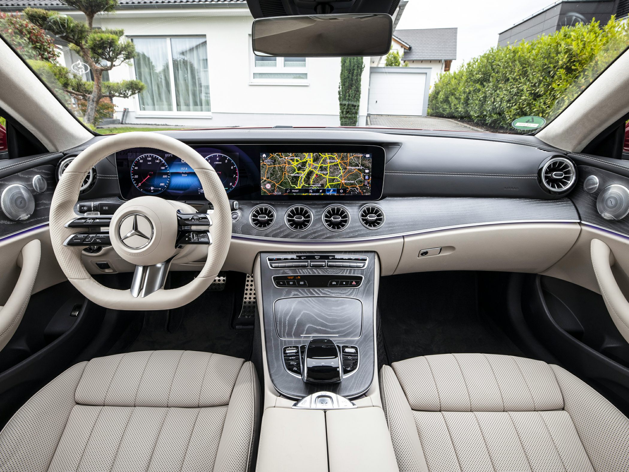 Luxury beige leather interior and digital dashboard with navigation of a premium convertible.