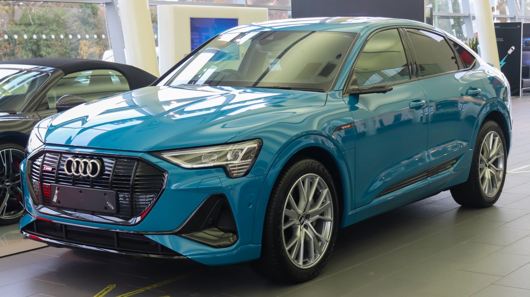 Blue electric SUV with coupe silhouette and signature grille