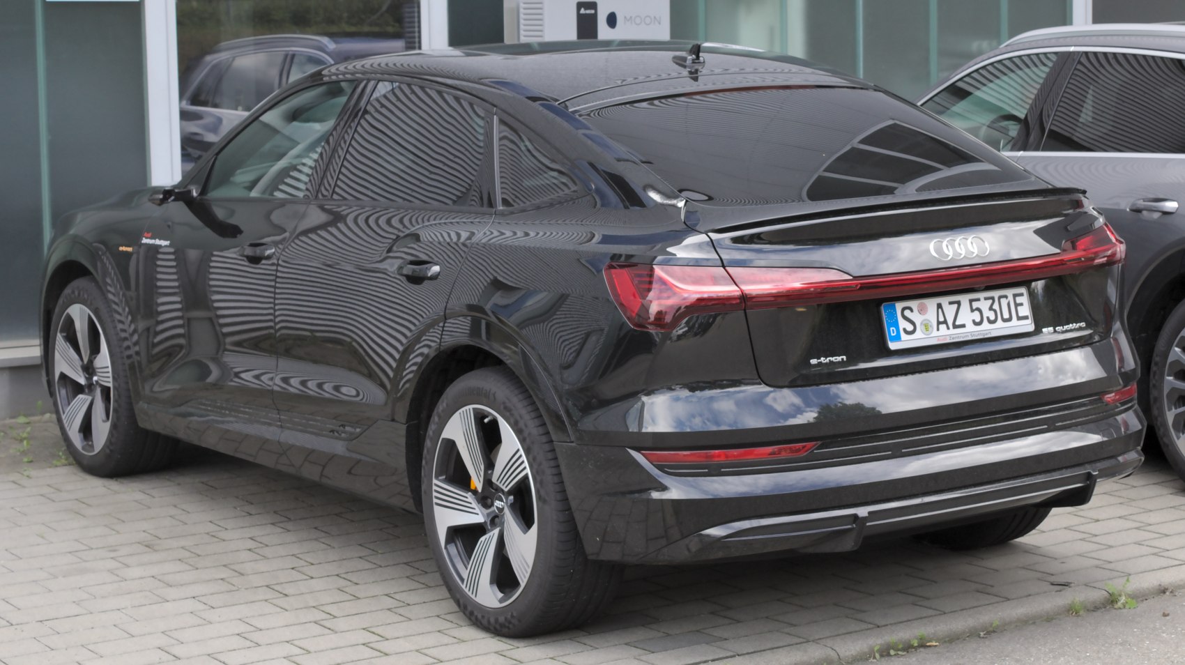 Rear and side view of a coupe-like electric SUV with distinct LED tail lights and aerodynamic design.