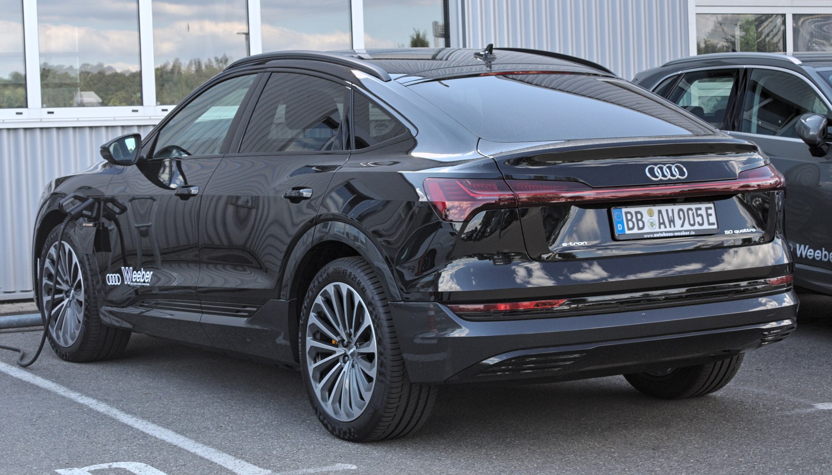 Rear side view of electric SUV at charging station
