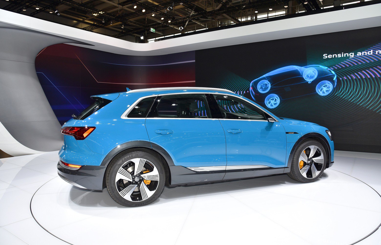 Side view of a blue electric SUV with distinctive aerodynamic wheels.