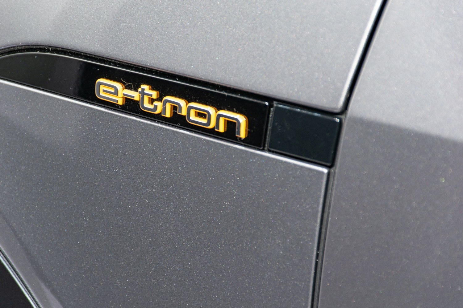 Close-up of an illuminated e-tron emblem on vehicle body