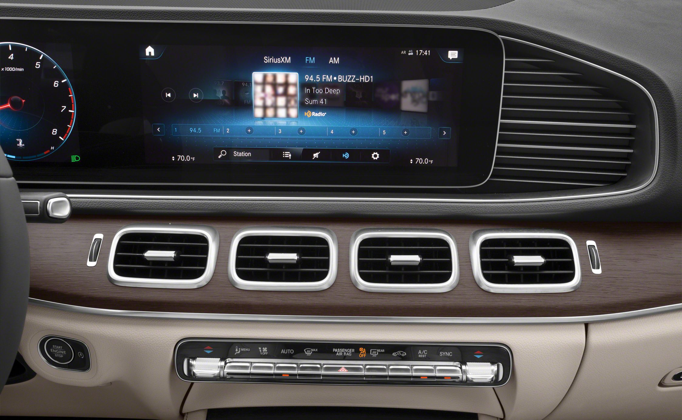 Digital multimedia display and four rectangular air vents on wood-trimmed dashboard