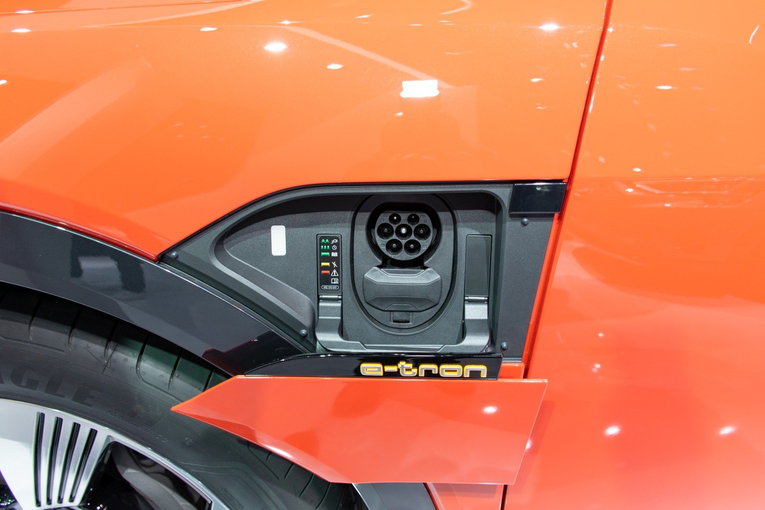 Close-up of an electric vehicle charging port with e-tron branding