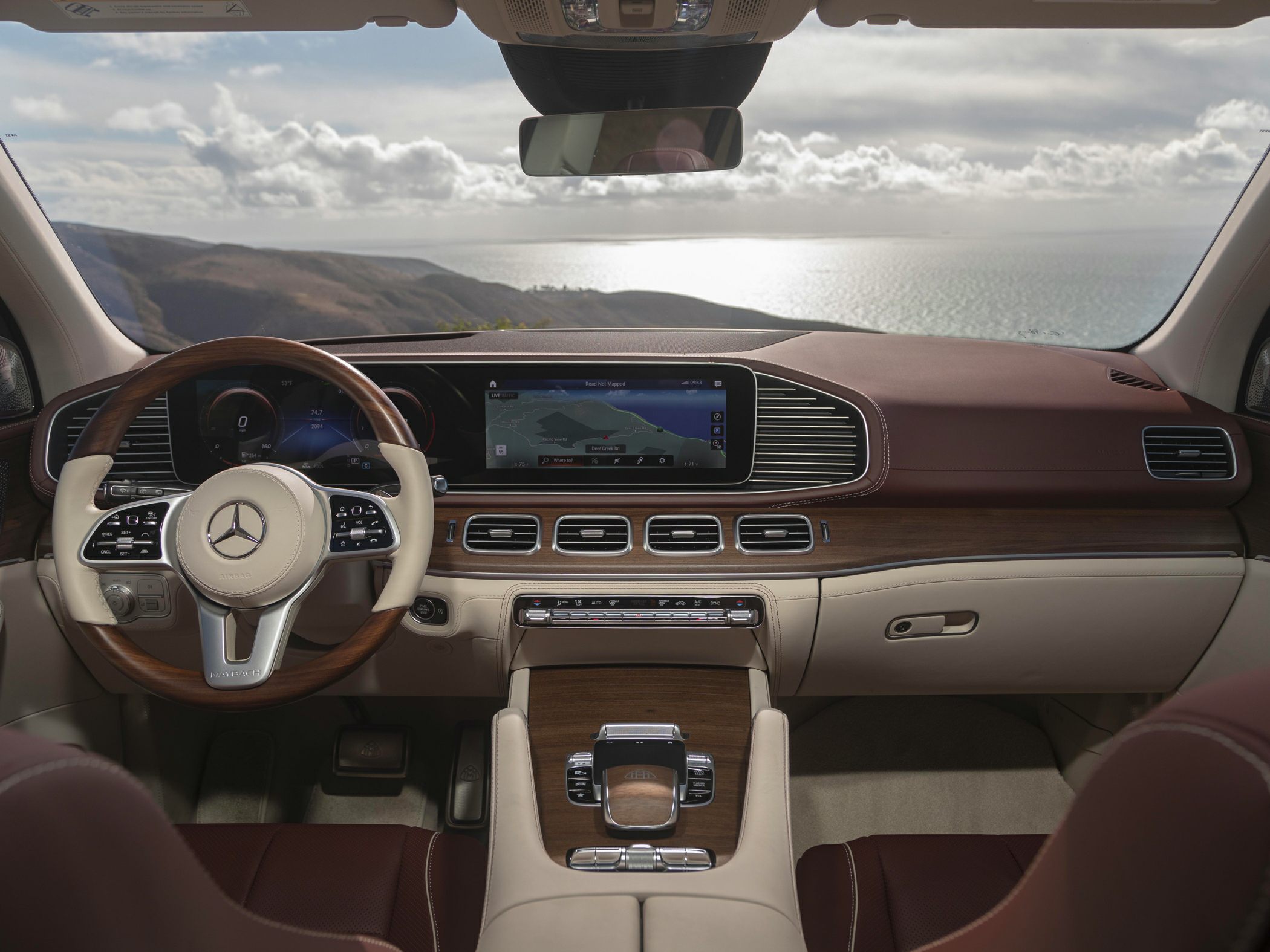 Luxury SUV interior with wooden steering wheel and large digital dashboard