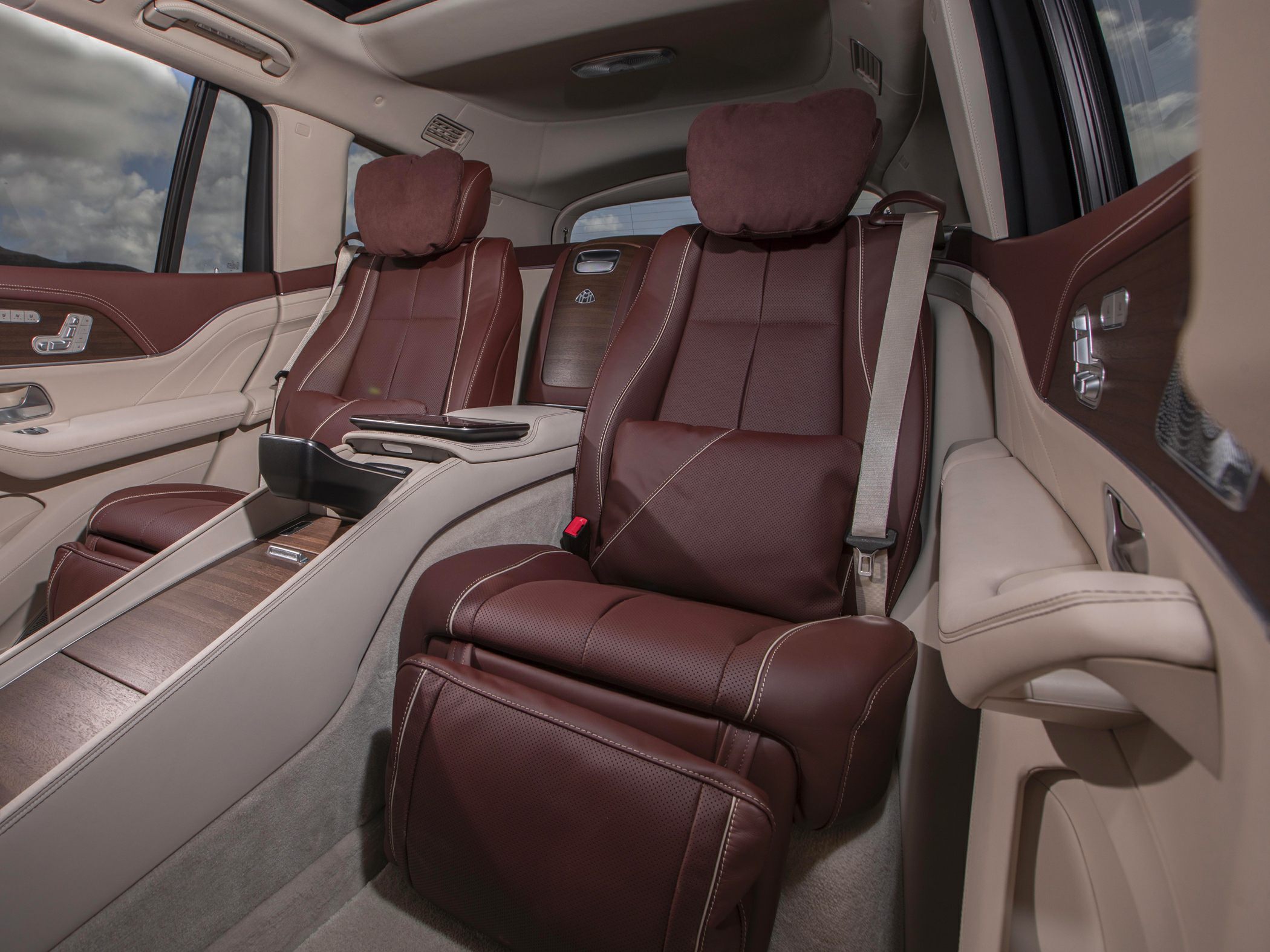 Plush rear leather seats with adjustable headrests and wood trim accents