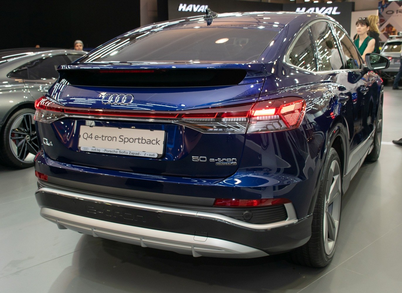 Rear view of a blue electric SUV with LED tail lights and sportback design.