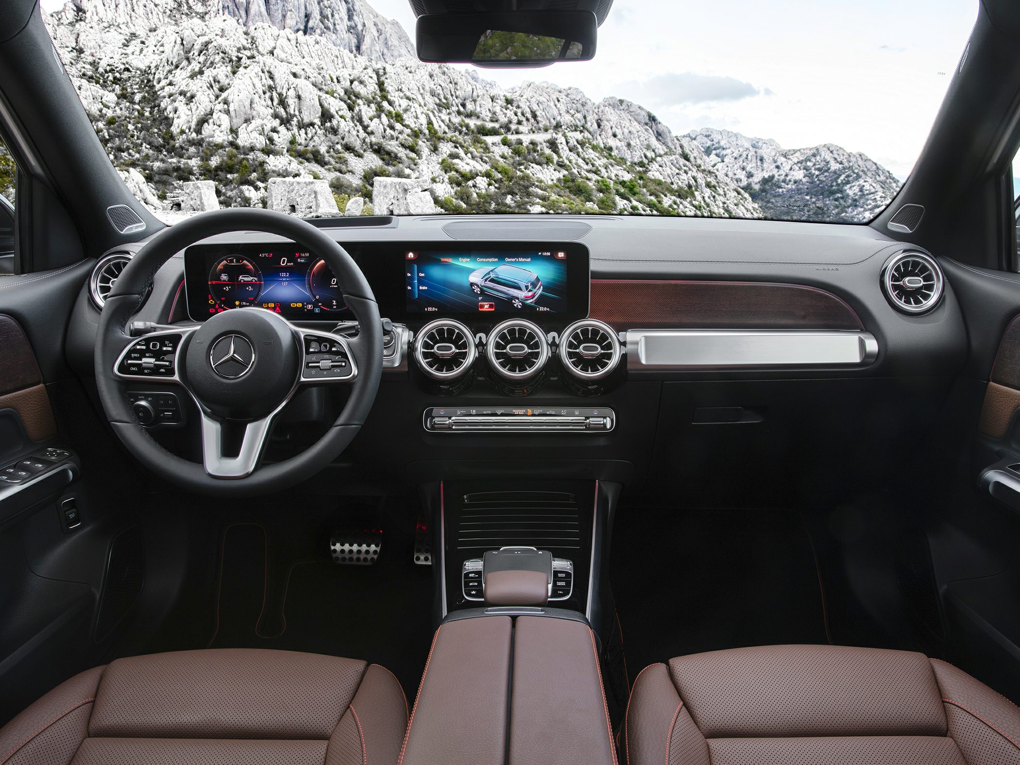 Luxury car interior with digital instrument cluster and infotainment screens.