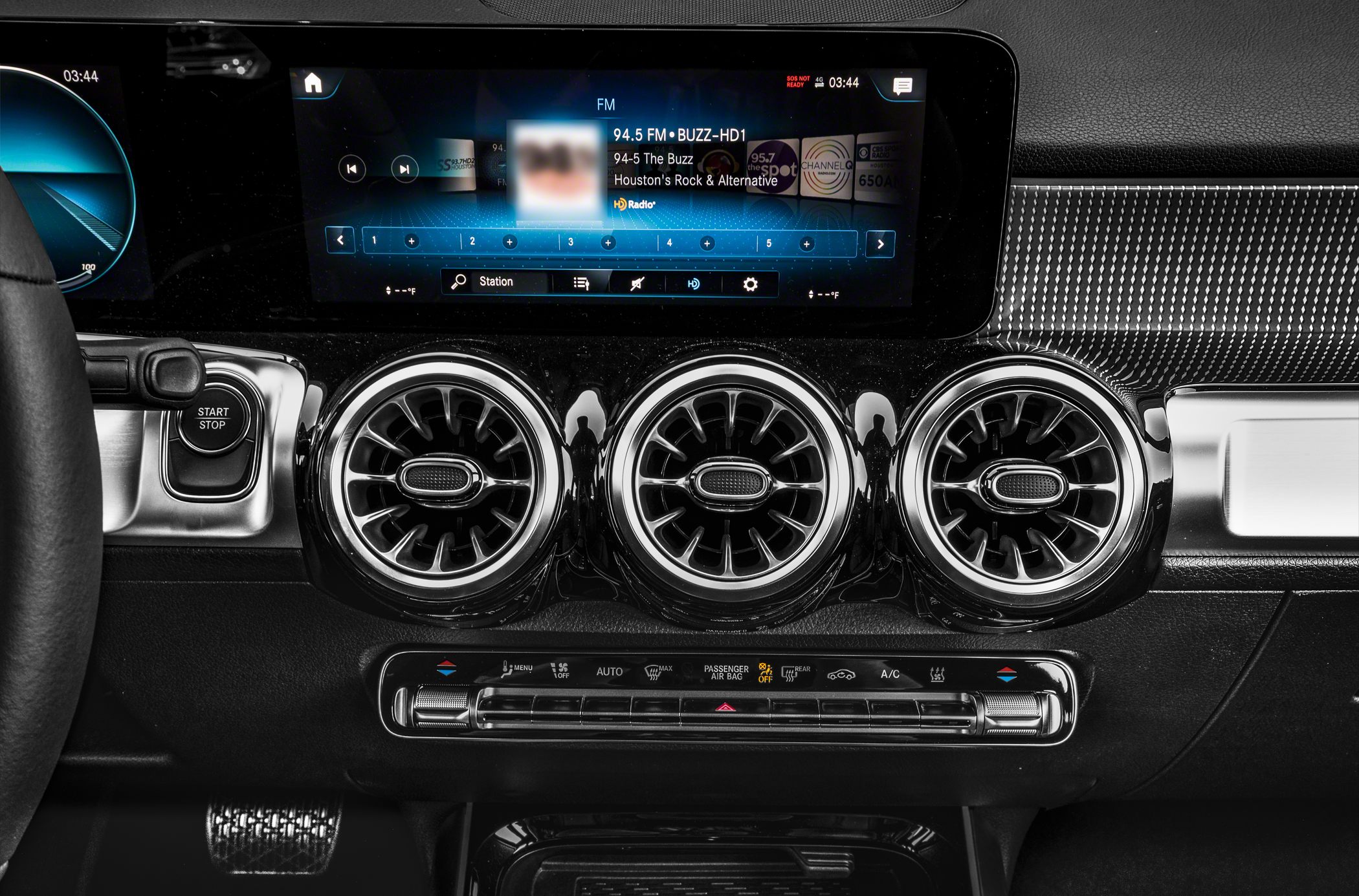 Infotainment screen with triple circular air vents and climate controls