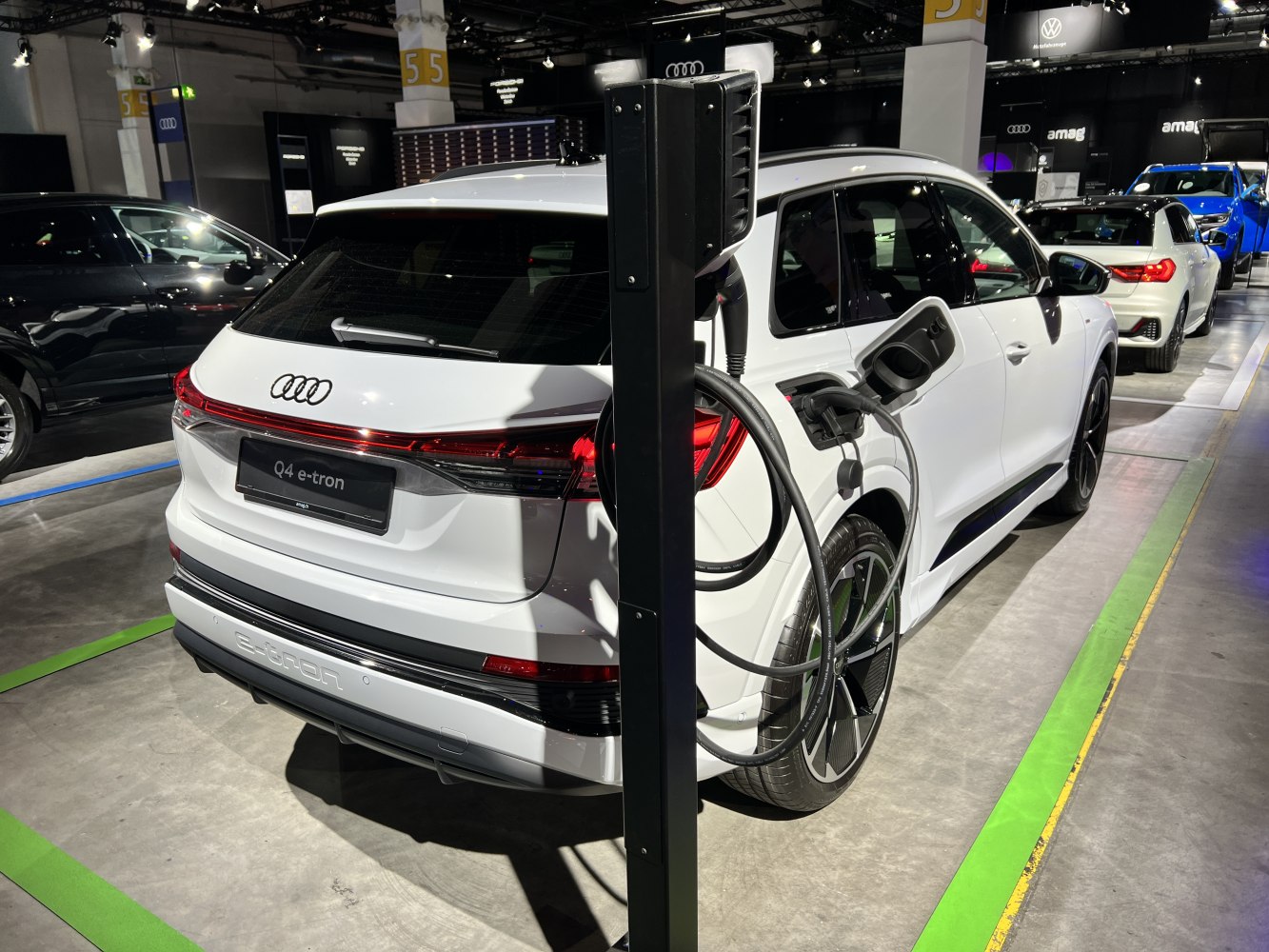 White electric SUV plugged in at charging station