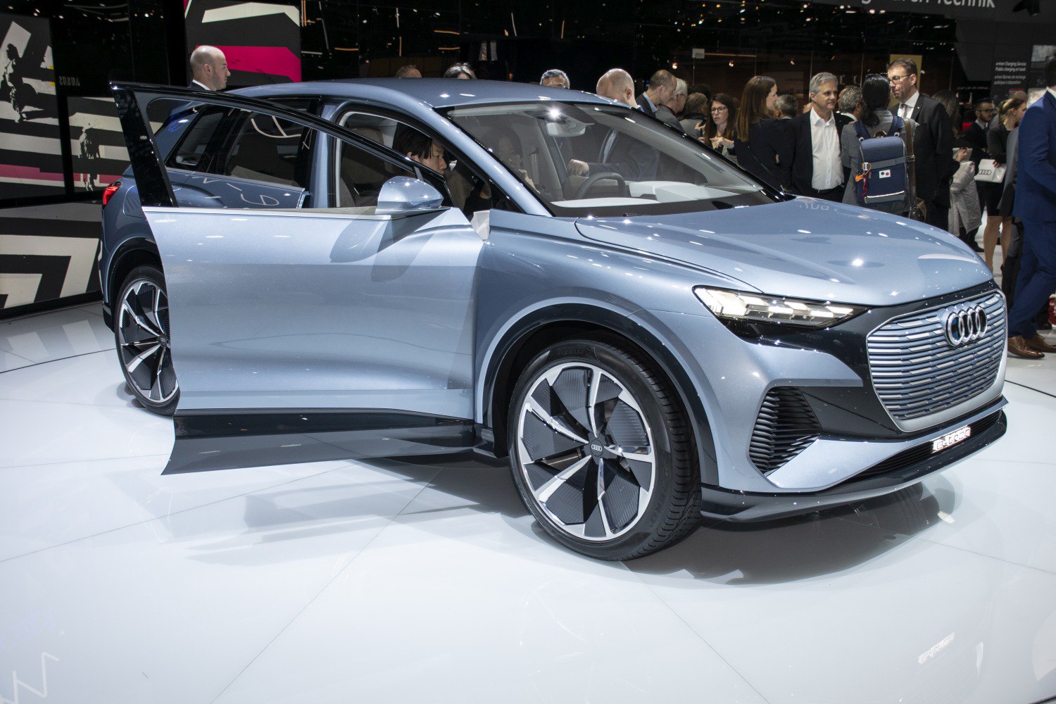 Front view with LED headlights, signature grille, open door, large aerodynamic wheels