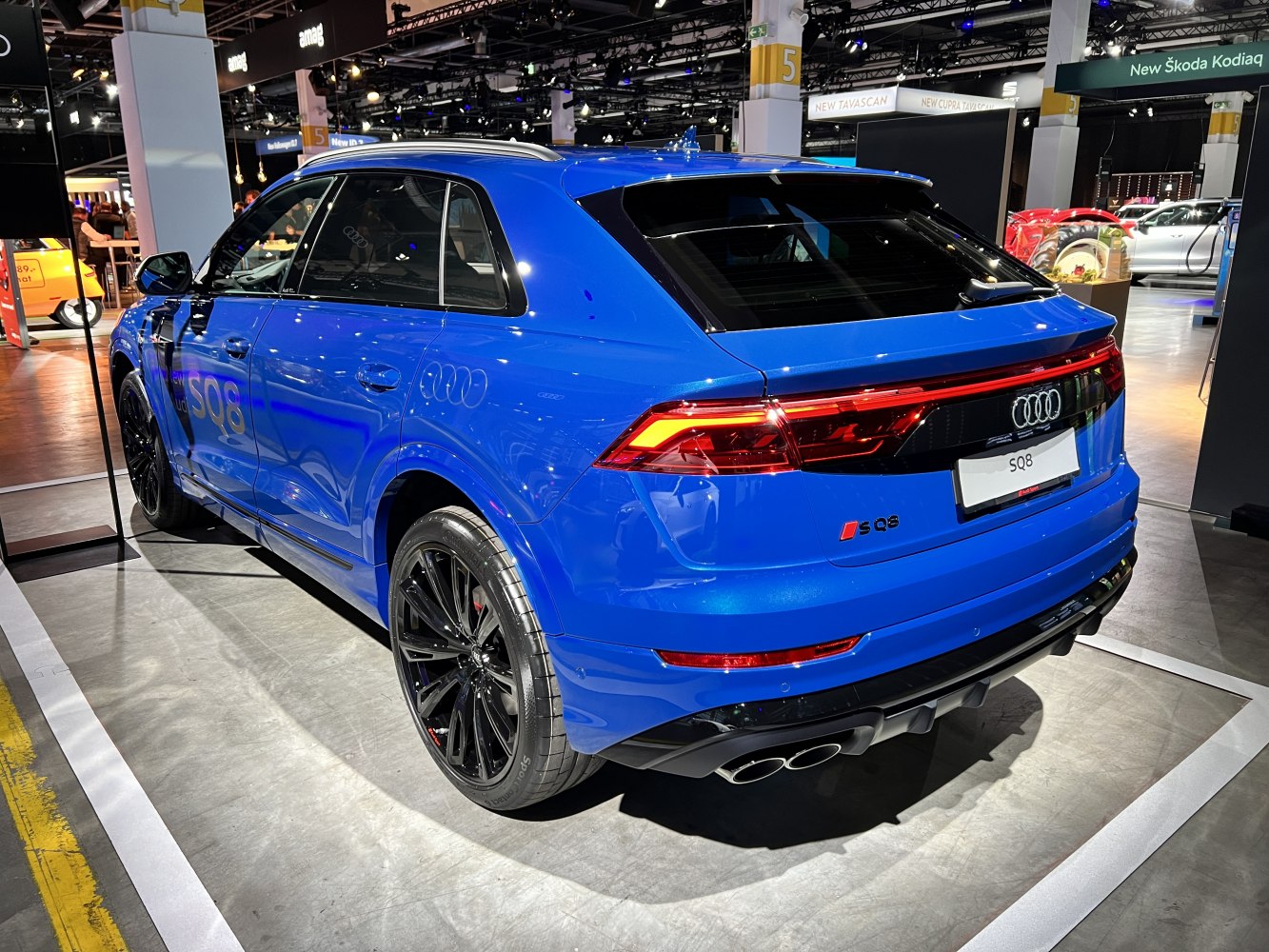 Rear side view of blue SUV with quad exhausts and black wheels
