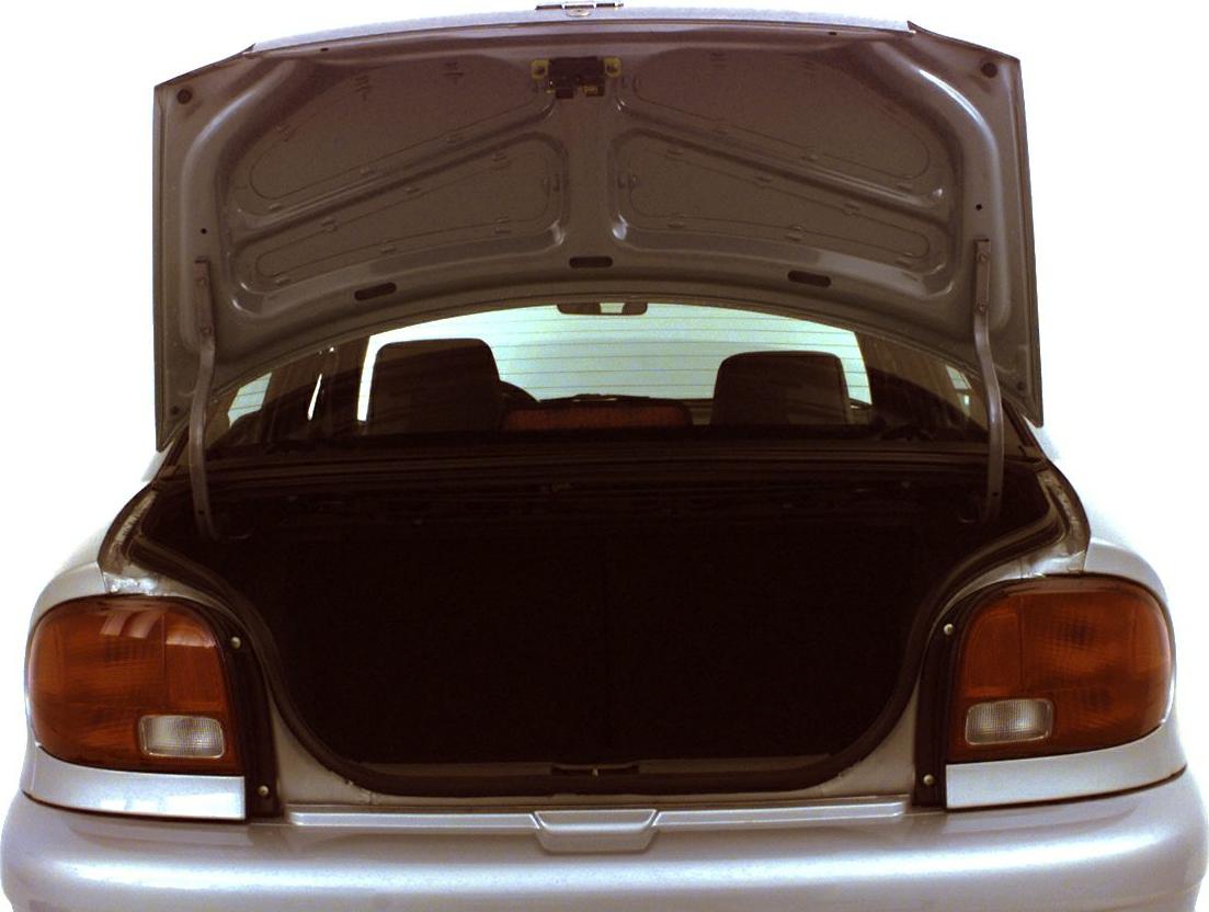 Open trunk and rear taillights of a compact sedan