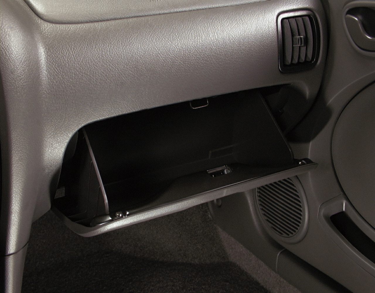 Open glovebox and dashboard air vent in car interior