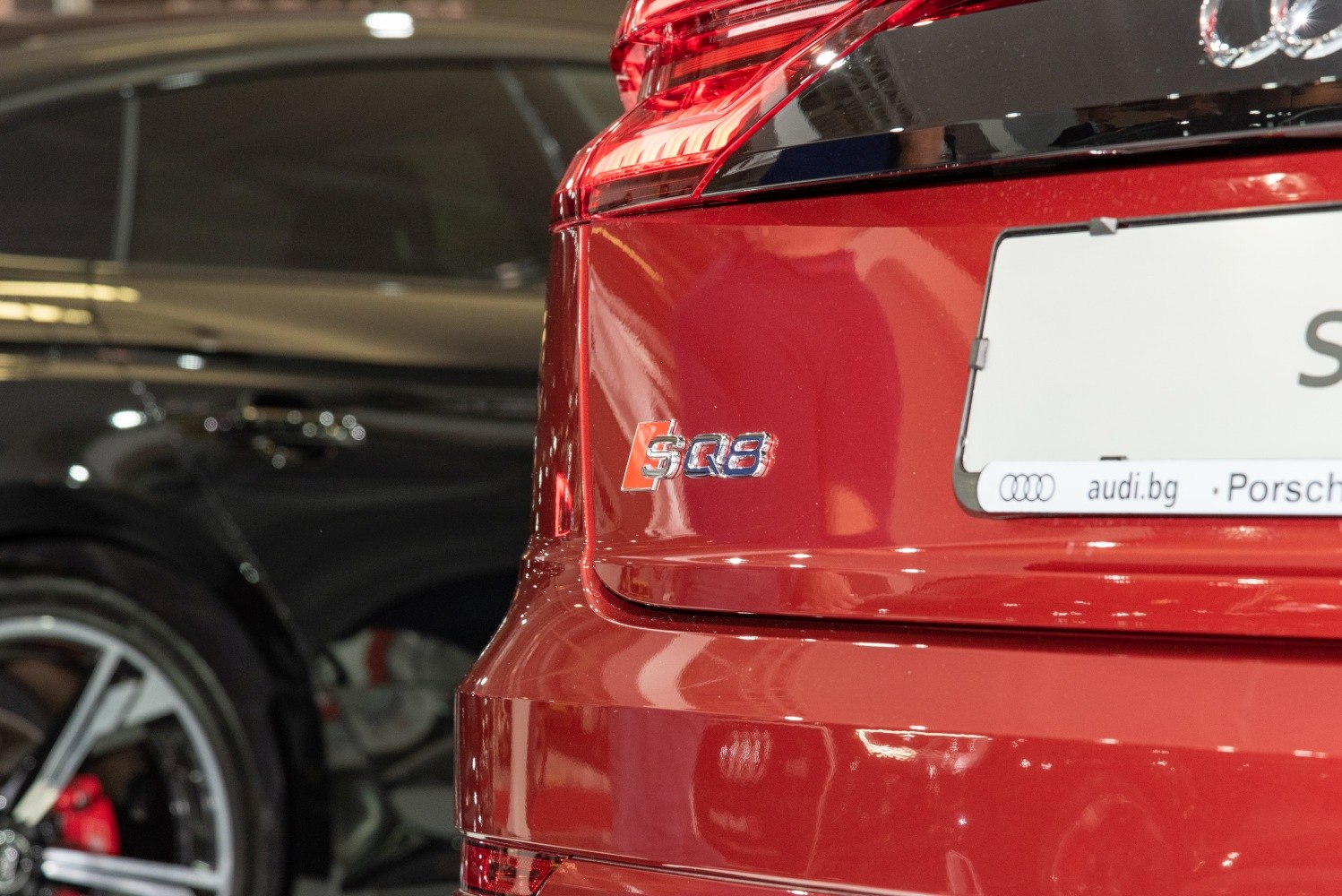 Close-up of rear SQ8 badge and tail light on red SUV
