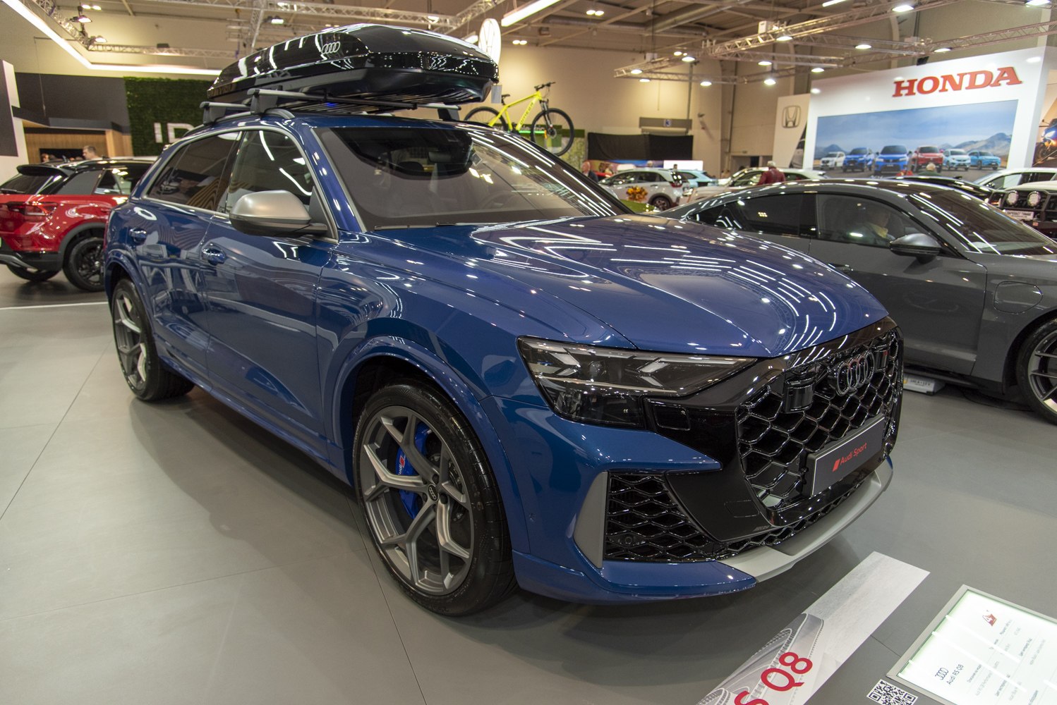 Blue sporty SUV with black honeycomb grille and roof cargo box