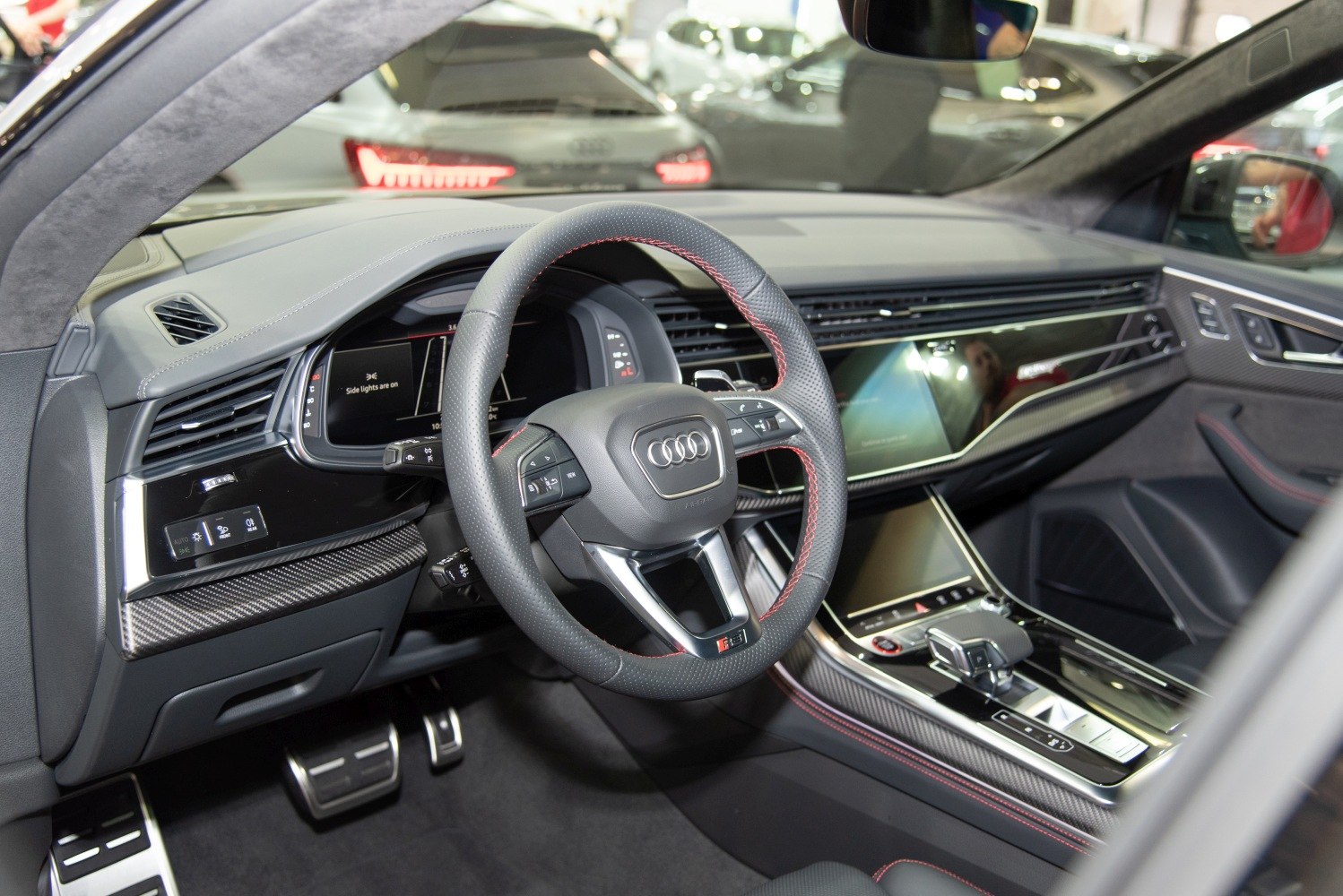 Sporty perforated steering wheel with red stitching and digital dashboard