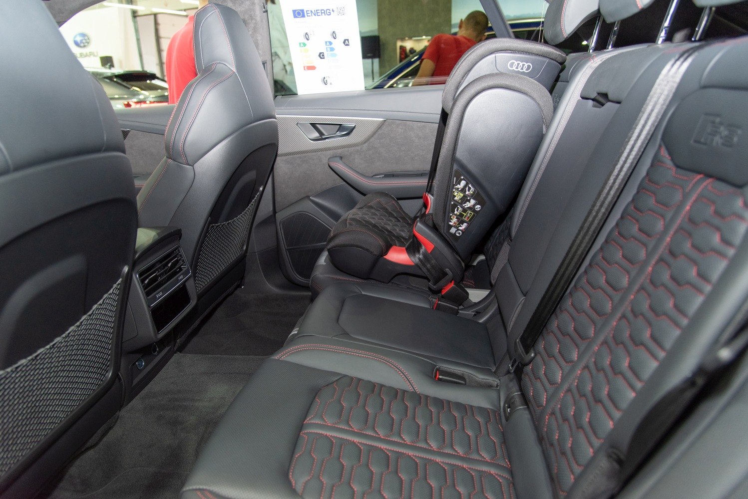 Rear leather seats with red stitching and child safety seat