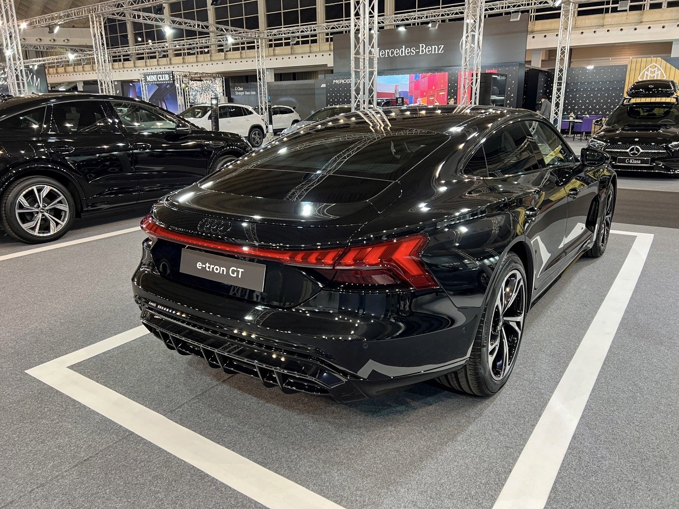 Aggressive rear diffuser and LED tail light strip on sleek electric sports sedan.