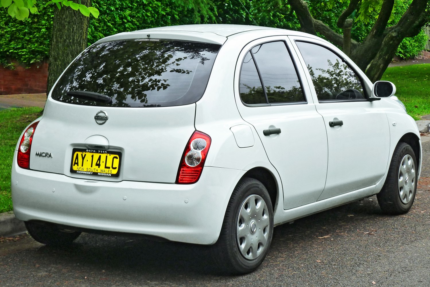 White hatchback with rounded taillights and tinted rear windows
