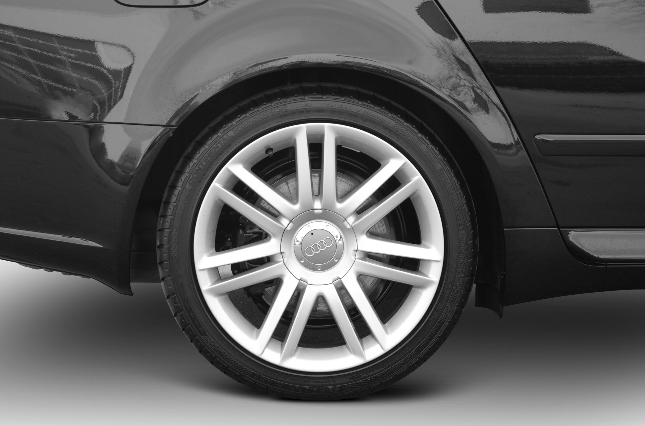 Close-up of multi-spoke alloy wheel and tire on a vehicle rear quarter