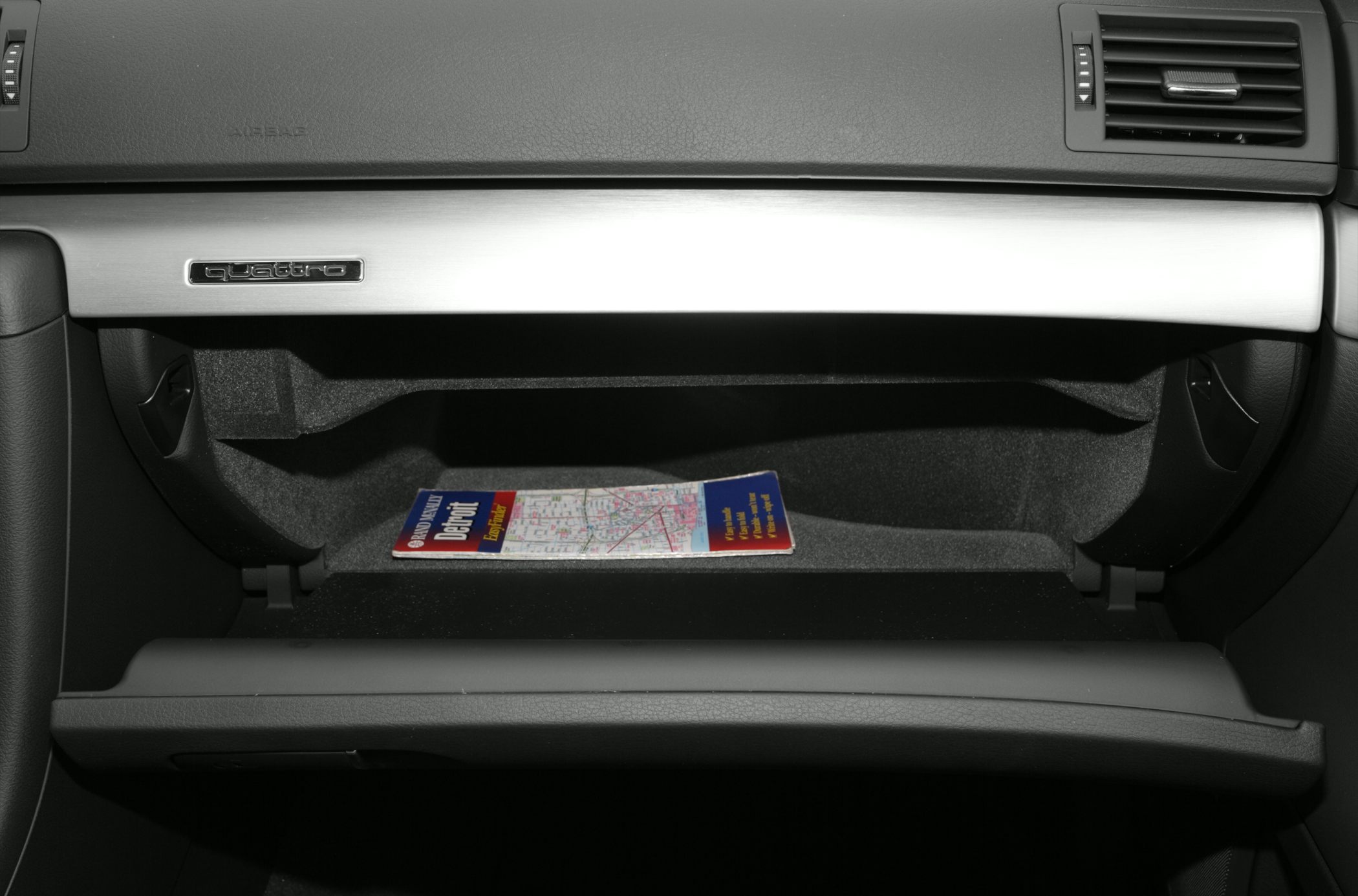 Open glovebox with quattro emblem and map inside