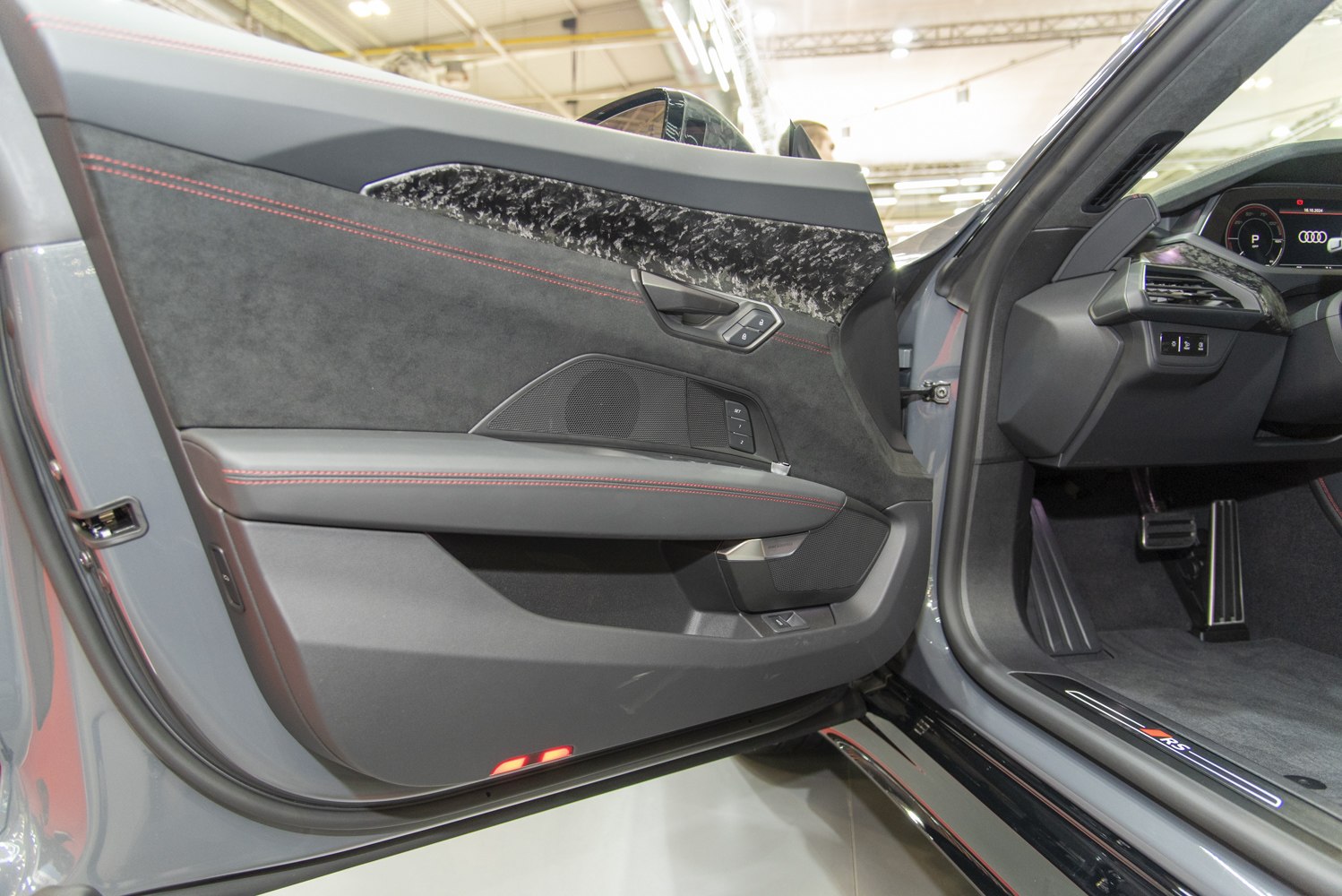 Luxury electric vehicle door panel with red stitching and control buttons