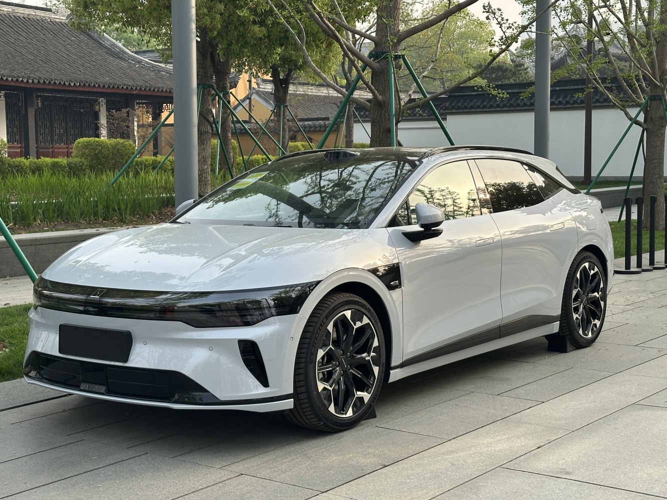 White electric sedan with glossy black roof and angular LED headlights.