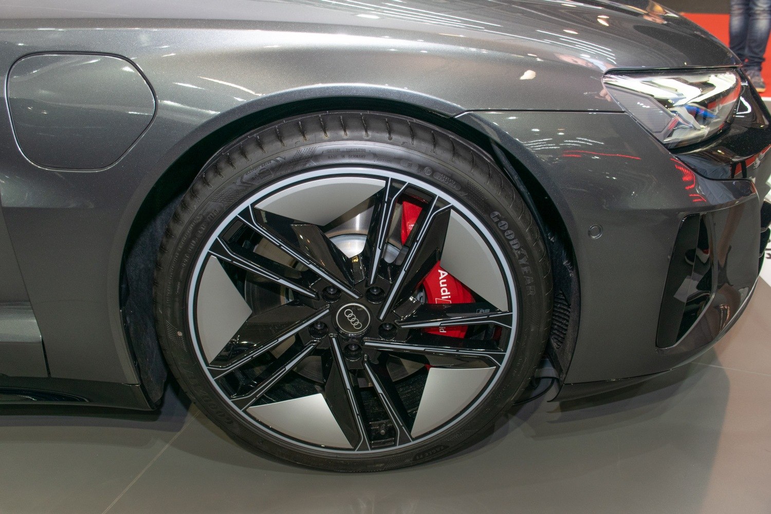 Close-up of wheel rim and front LED headlight with red brake caliper