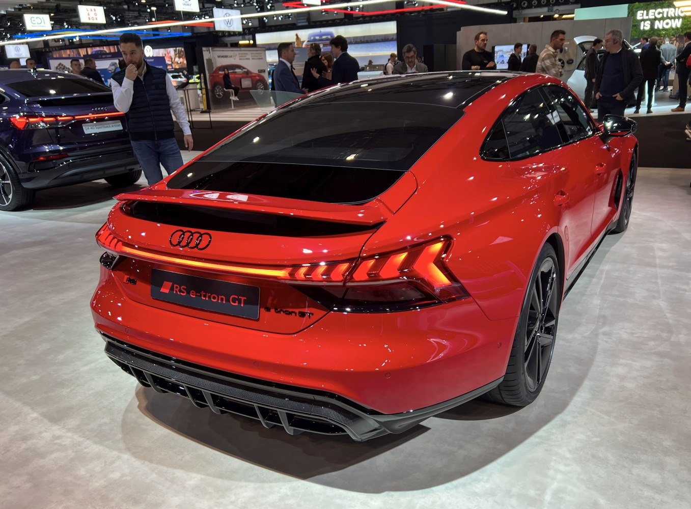 Rear view of red sports electric sedan with LED tail lights and black roof