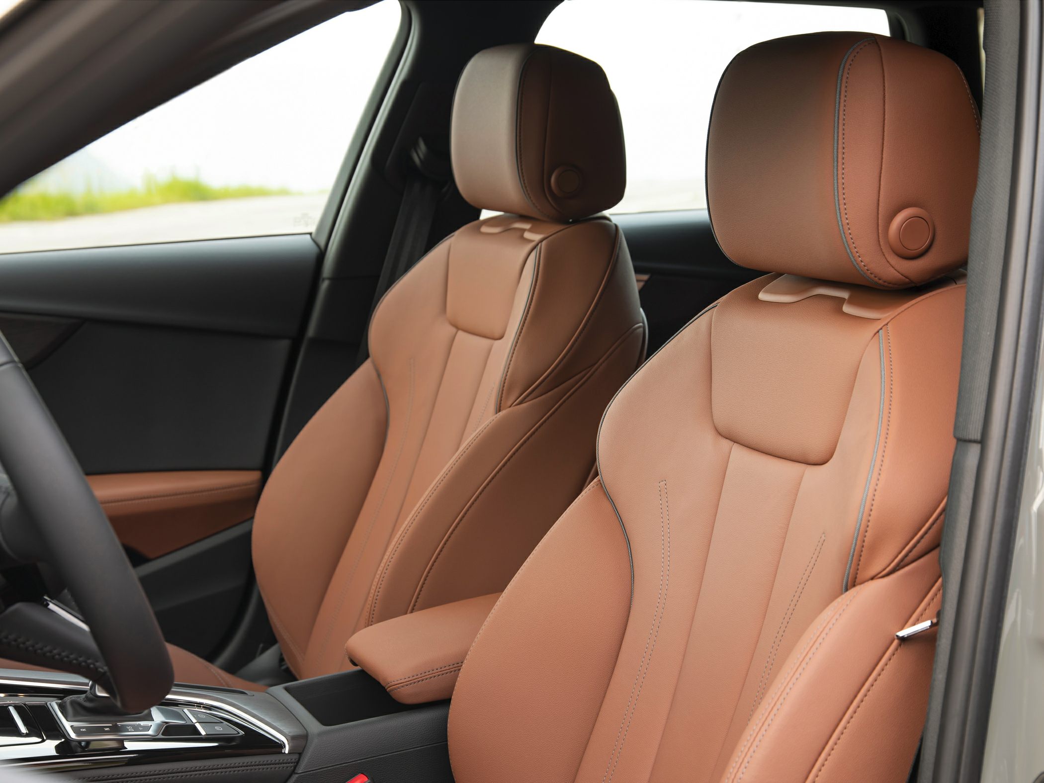 Ergonomic brown leather front seats with detailed stitching