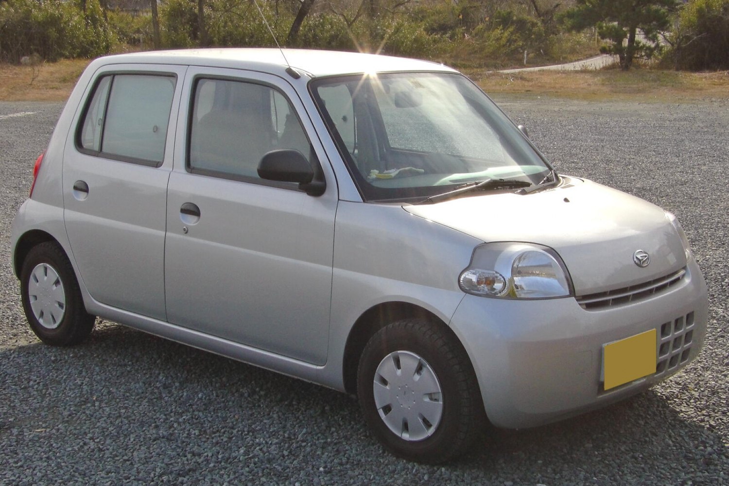 Compact hatchback with rounded headlights and simple wheel covers