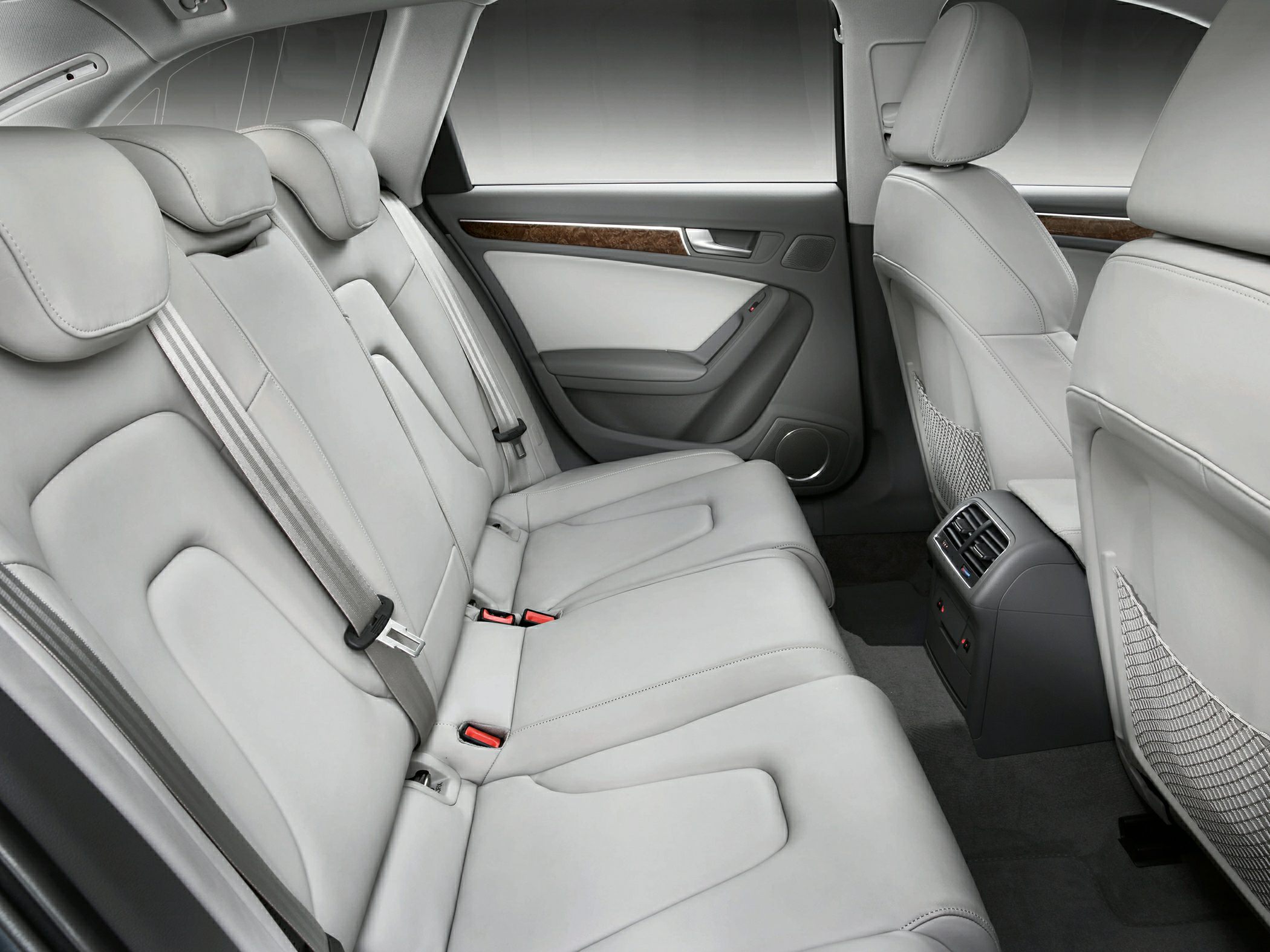Rear seat interior with light leather upholstery and wood trim