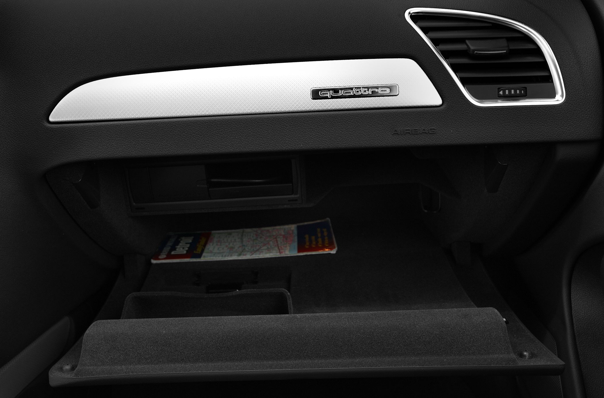 Open glovebox with quattro emblem on dashboard panel