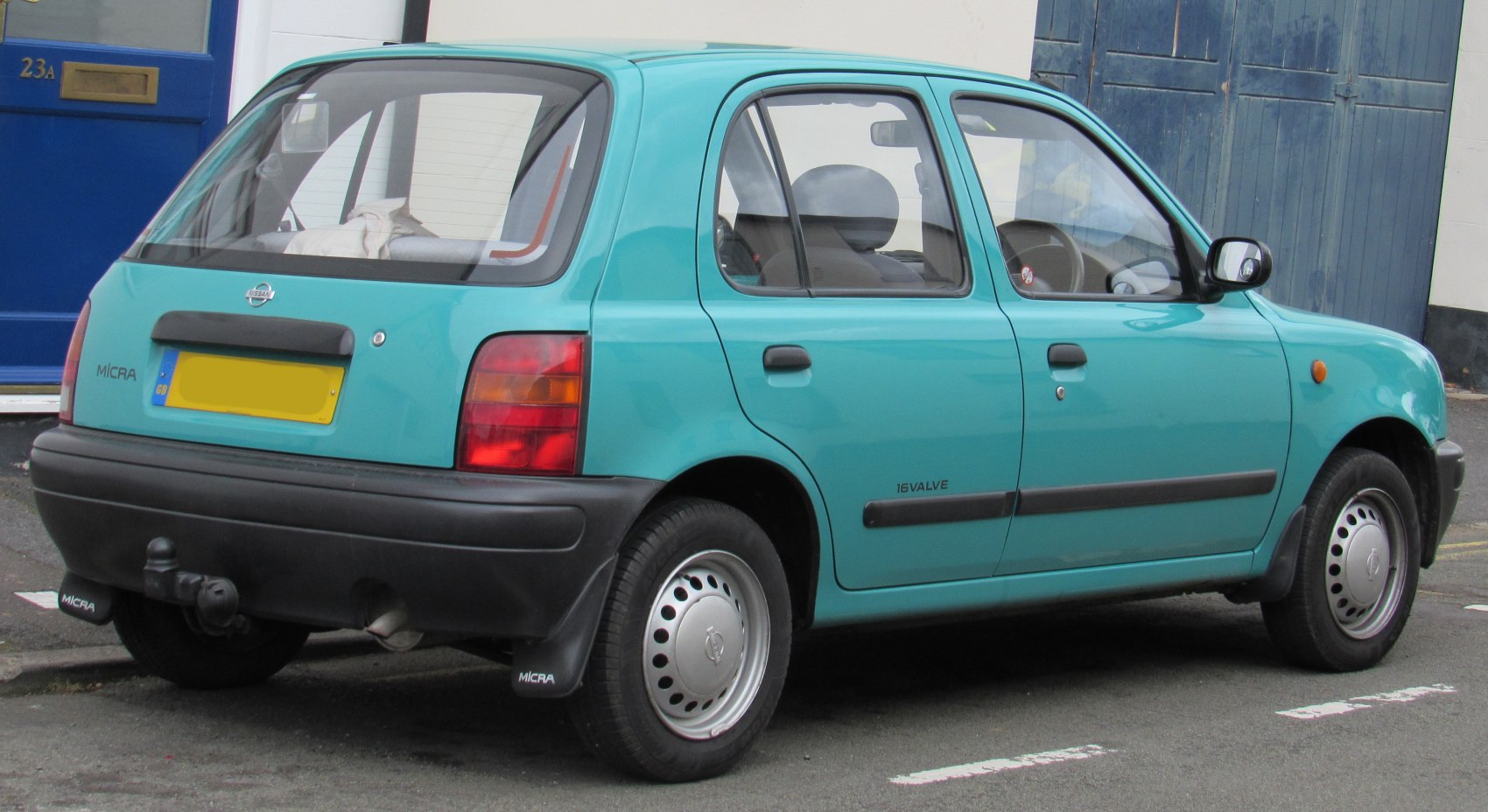 Rear side view of a compact hatchback with round tail lights