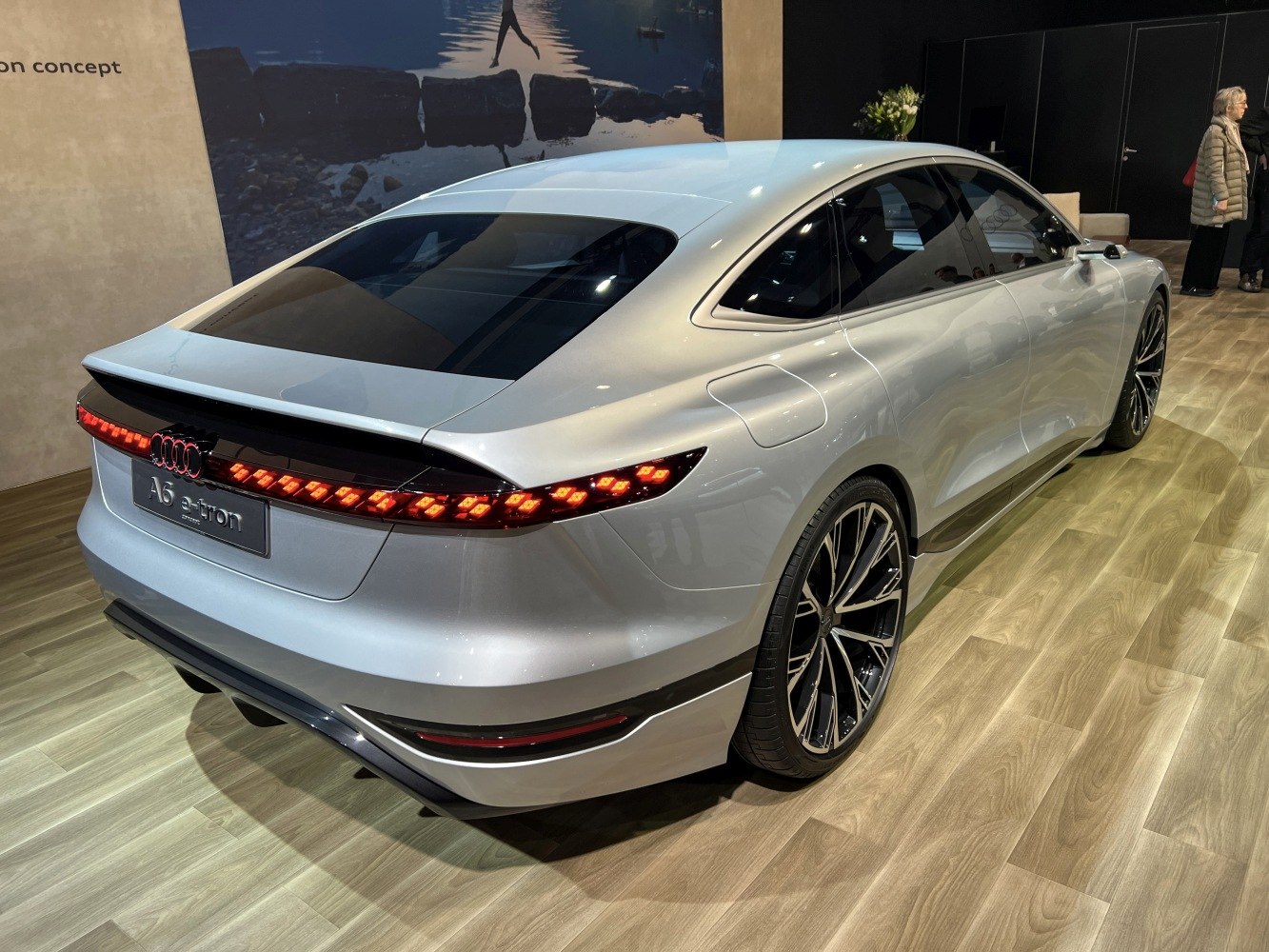 Rear and side electric sedan with illuminated tail lights and sporty alloy wheels