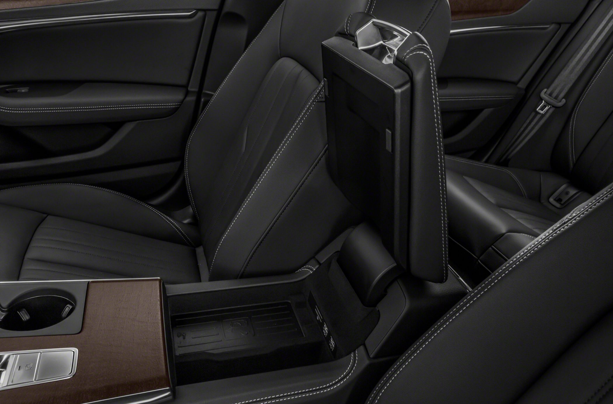 Black leather seats with white stitching and a wood-trimmed center console.