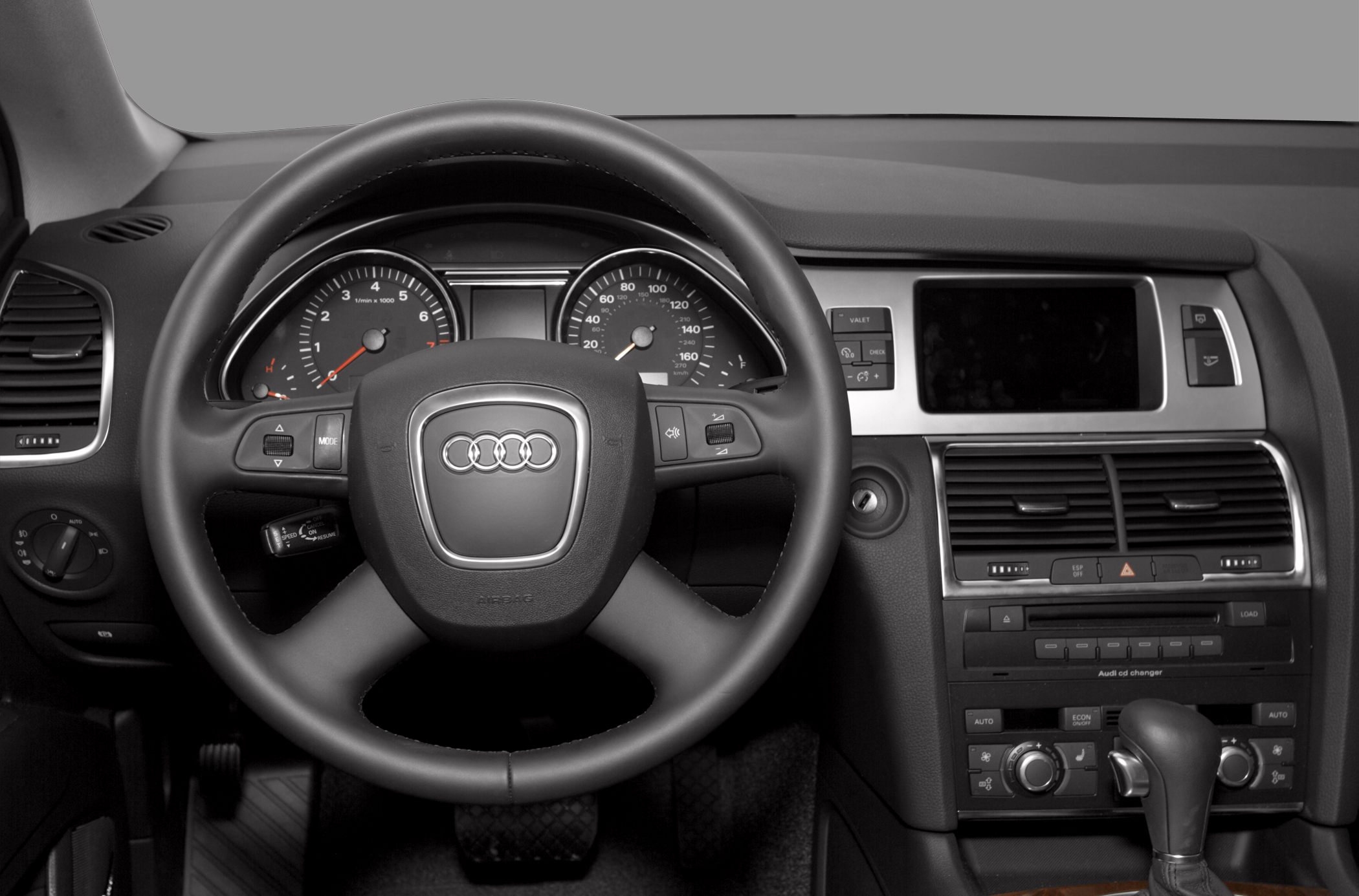 Steering wheel, dashboard with speedometer and tachometer, center console controls