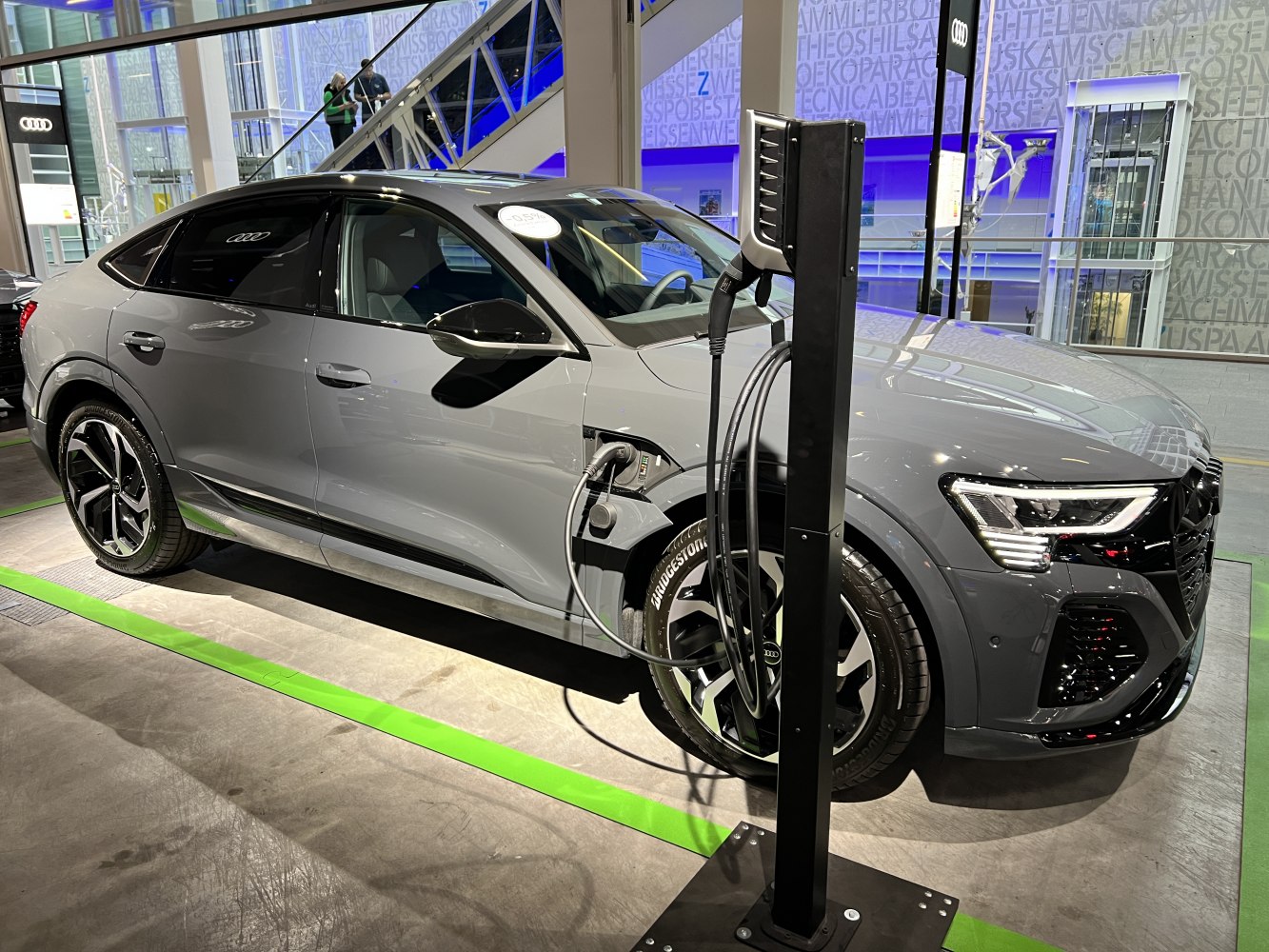 Electric coupe SUV at charging station in showroom
