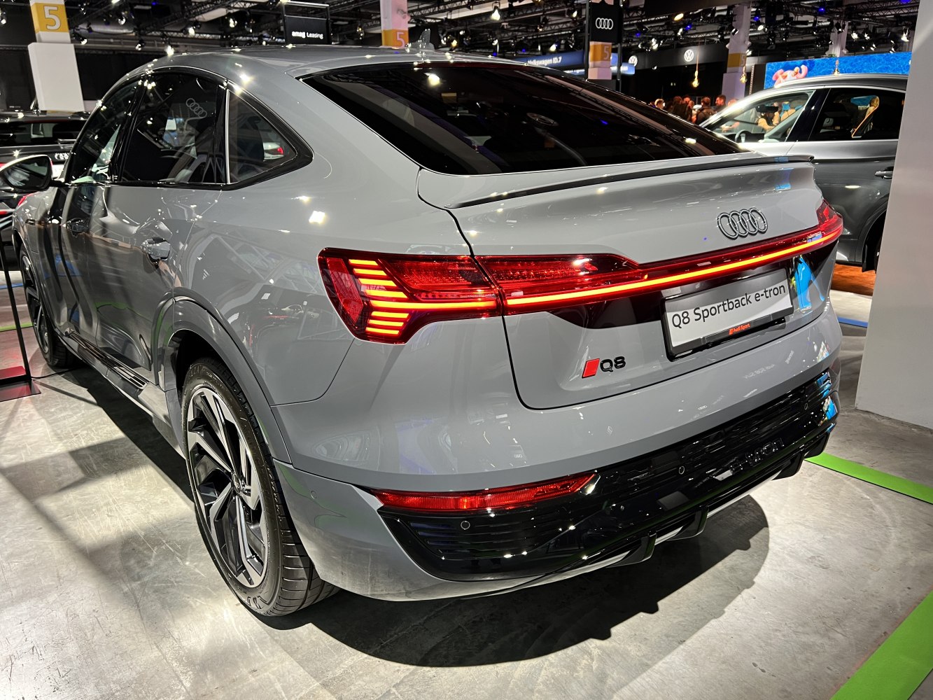 Rear view of electric SUV with LED tail lights and sloping roof.